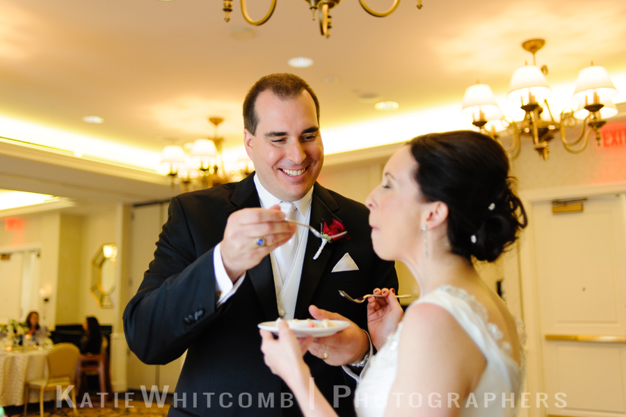 bride feeding groom cake at reception