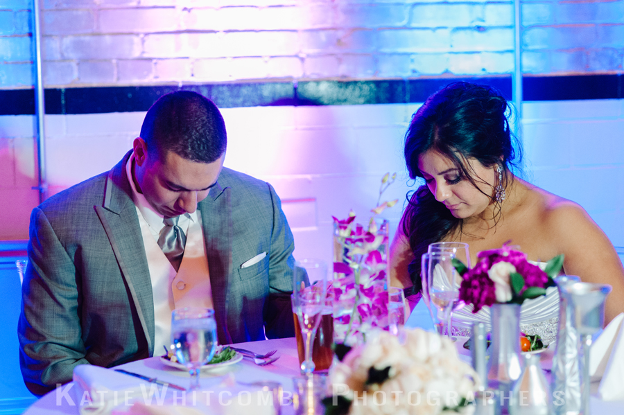 bride and groom praying during blessing at wedding reception at the brick