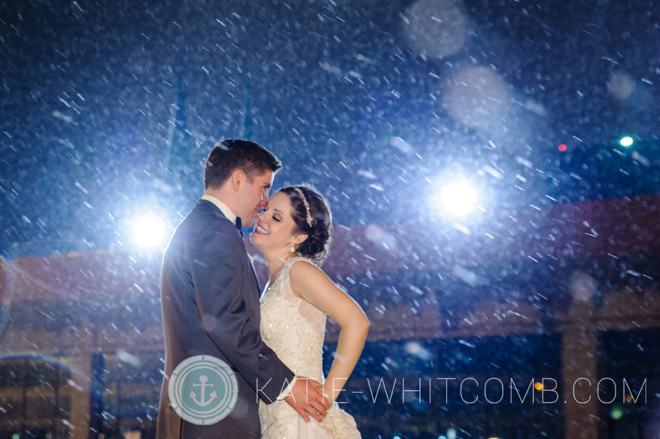 bride and groom in the snow at the end of their winter wedding reception at crown plaza indianpolis