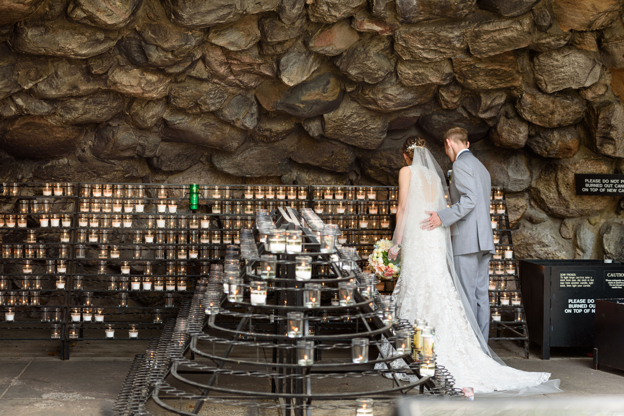 Wedding Couple lighting at candle at the Grotto on the campus of the University of Notre Dame