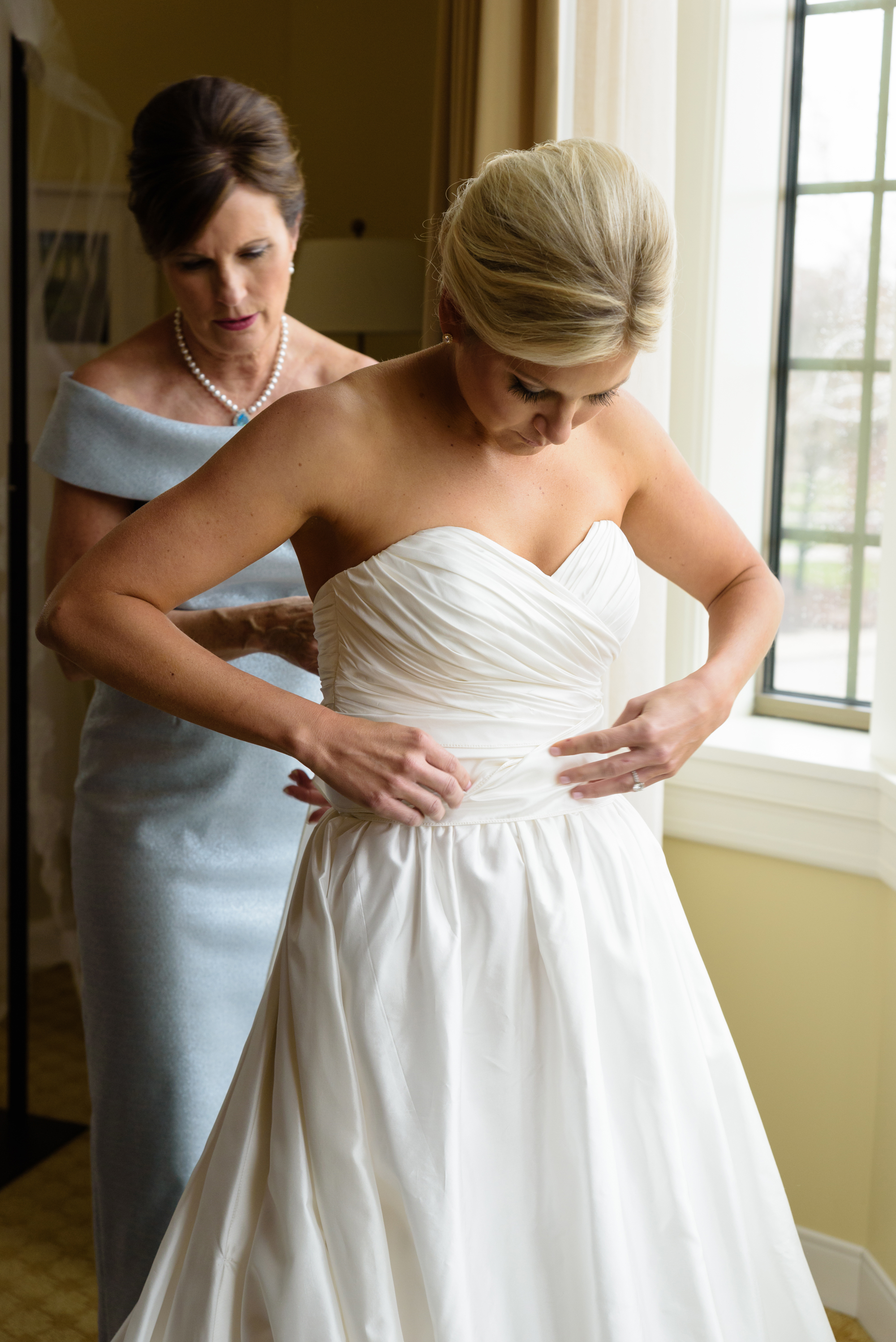 Bride getting in dress in the presidential suite at the Morris Inn on the campus of the University of Notre Dame