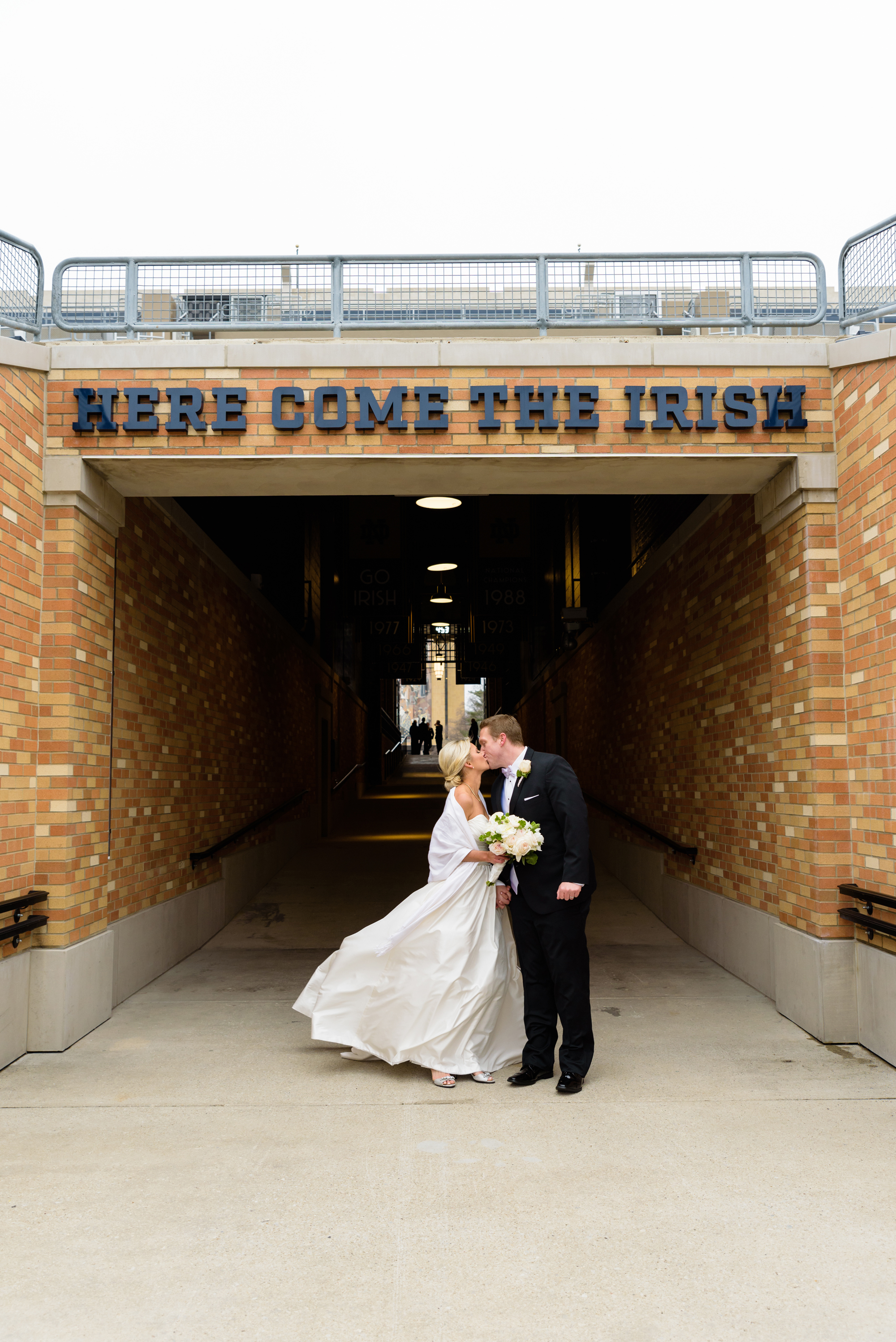 Bride & Groom in front of "Here Come the Irish" sign in the Stadium on the campus of University of Notre Dame