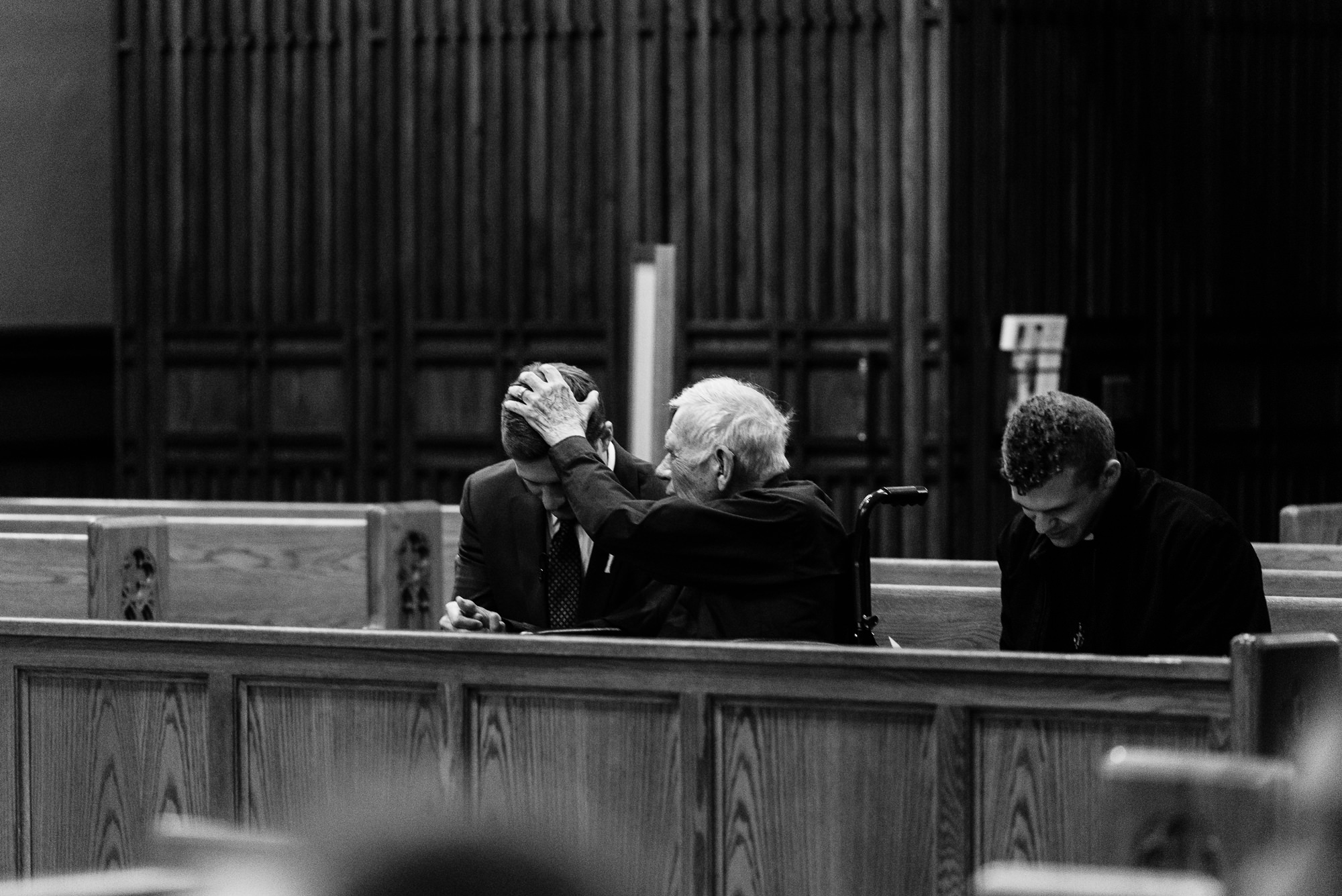 Groom being prayed over by the Priest before his wedding ceremony at the Basilica of the Sacred Heart on the campus of the University of Notre Dame