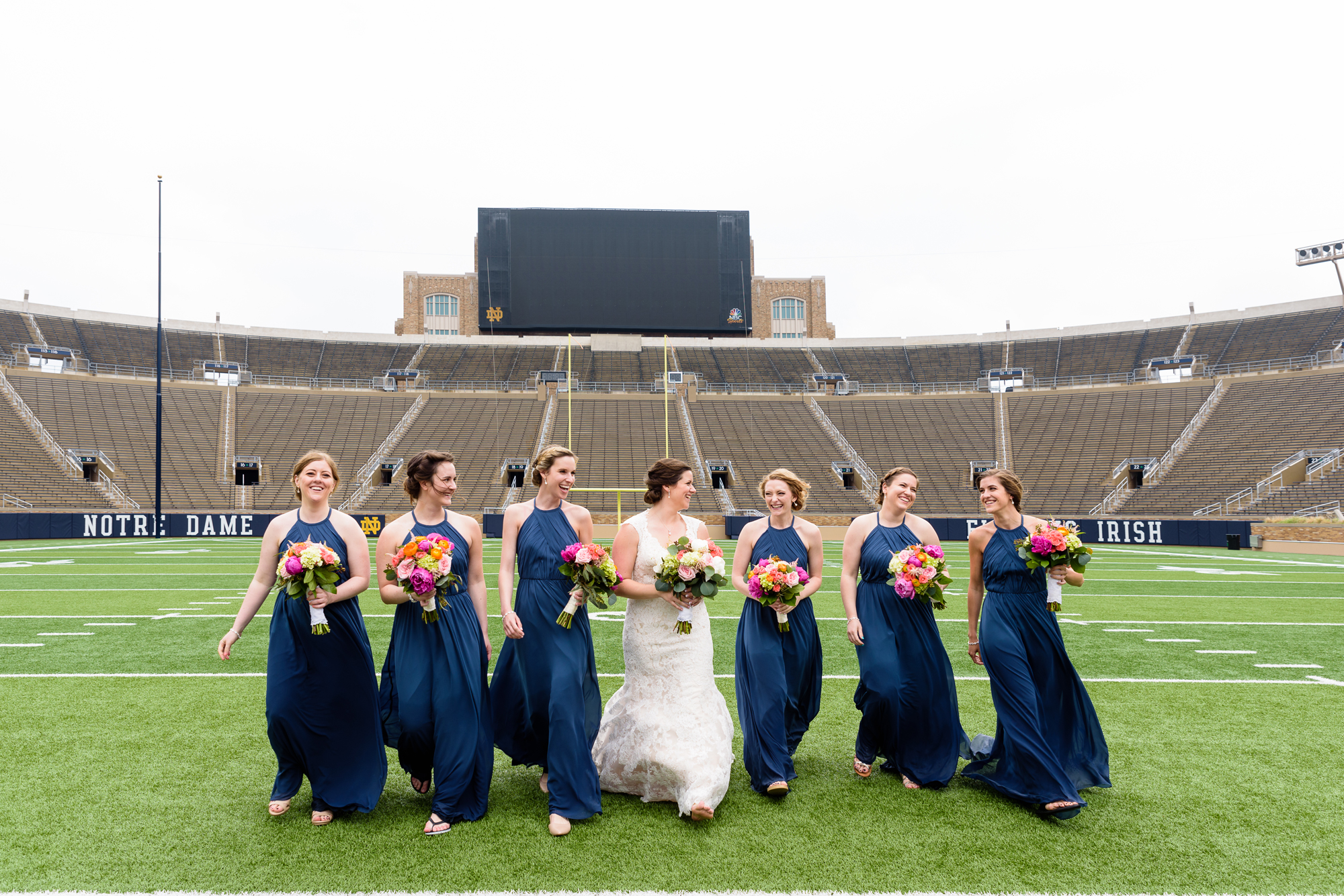 Bridesmaids on the field in the stadium after their wedding ceremony at the Basilica of the Sacred Heart on the campus of University of Notre Dame