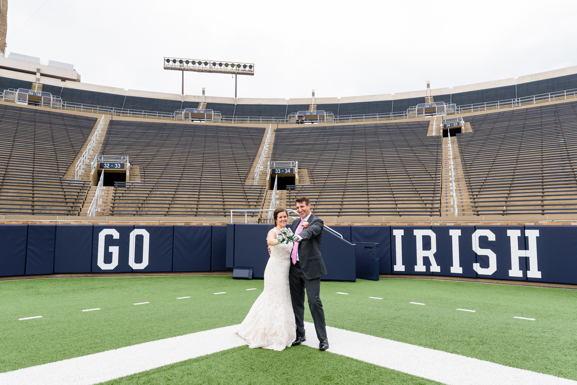 Bride & Groom on the field in the stadium after their wedding ceremony at the Basilica of the Sacred Heart on the campus of University of Notre Dame