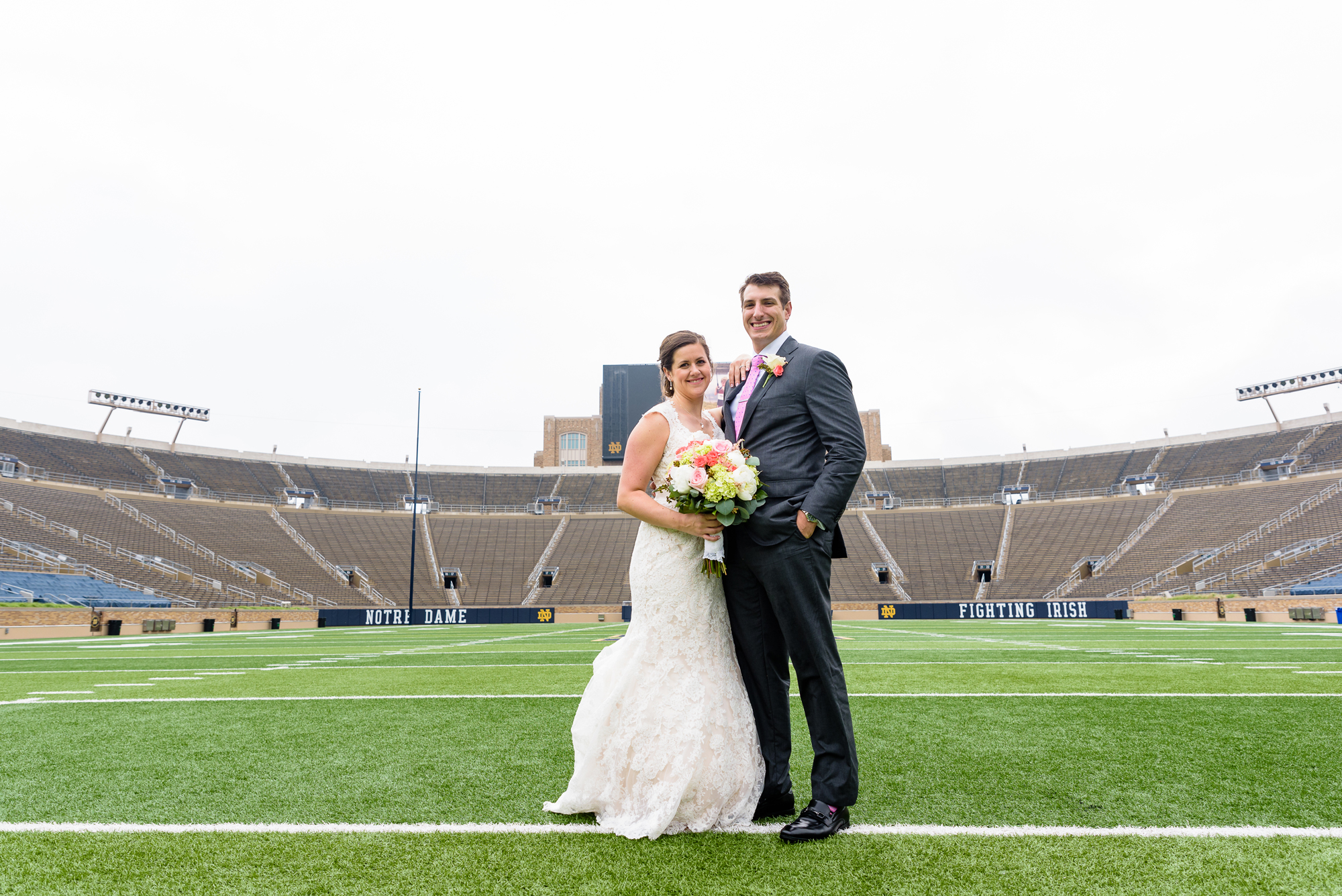 Bride & Groom on the field in the stadium after their wedding ceremony at the Basilica of the Sacred Heart on the campus of University of Notre Dame