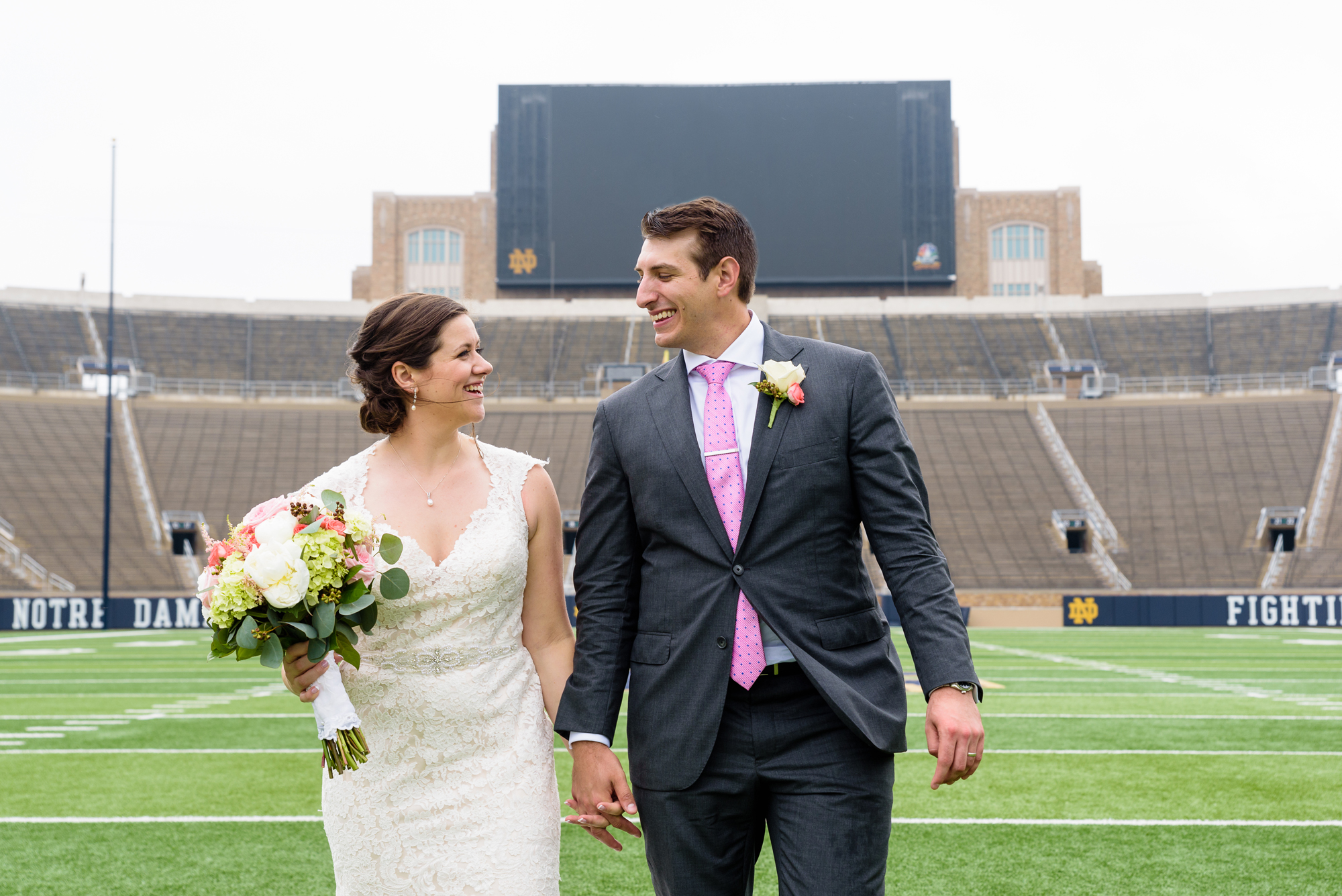 Bride & Groom on the field in the stadium after their wedding ceremony at the Basilica of the Sacred Heart on the campus of University of Notre Dame