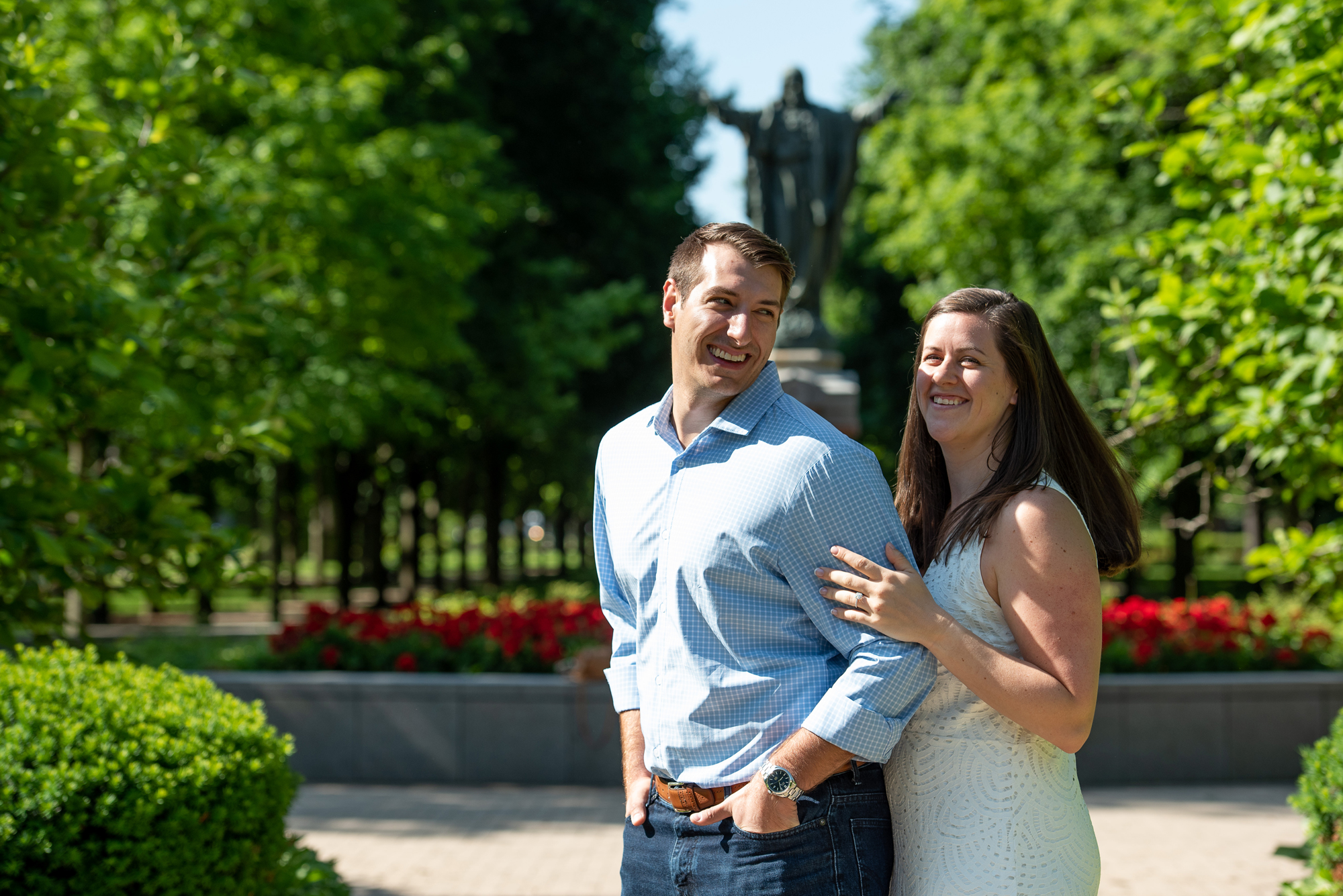 Couple on God Quad in front of the Jesus Statue on the campus of University of Notre Dame