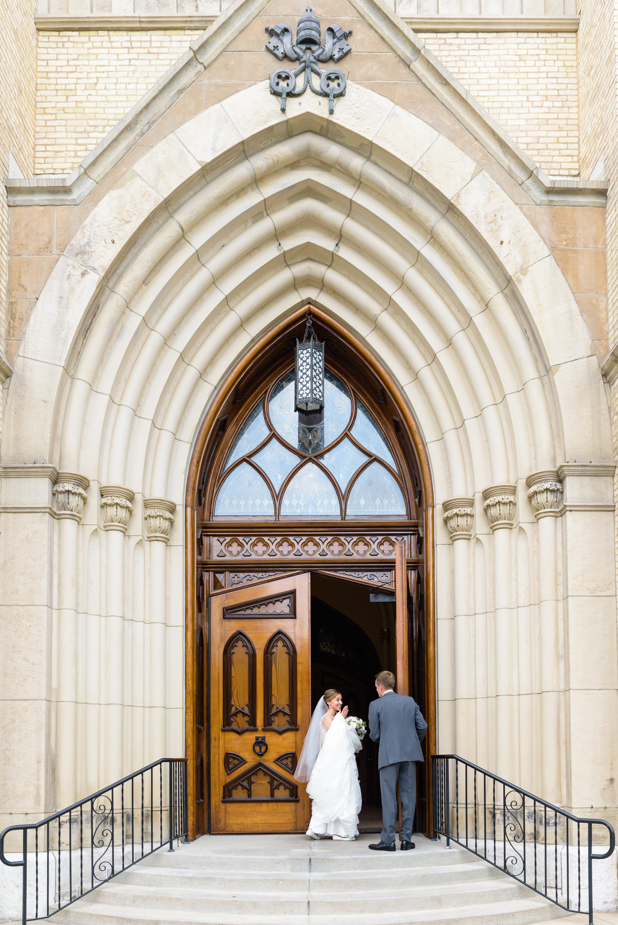 Groom escorting his Bride into the vestibule before their wedding ceremony at the Basilica of the Sacred Heart on the campus of the University of Notre Dame