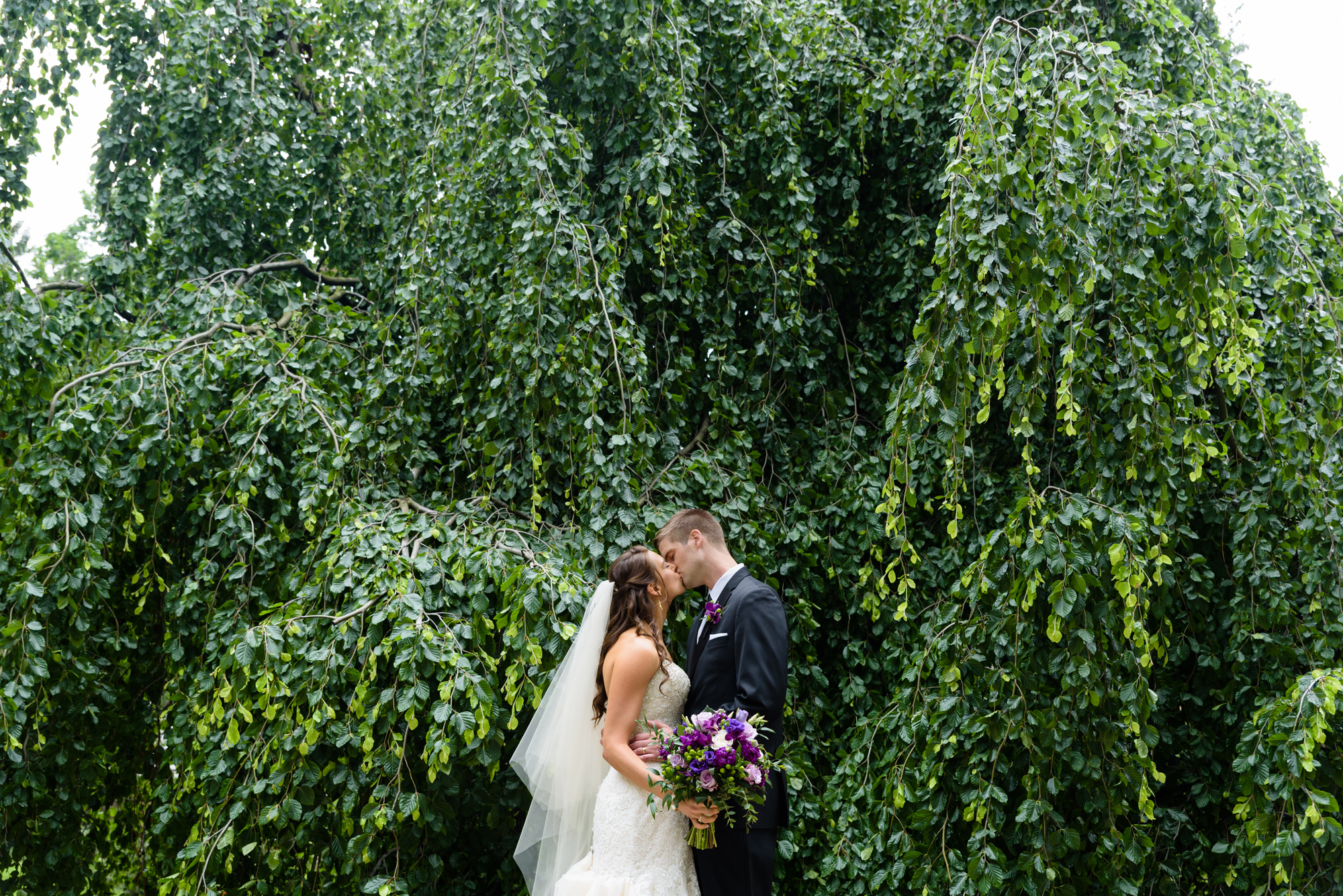 Bride & Groom in front of an exotic California inspired tree after their wedding ceremony at the Basilica of the Sacred Heart on the campus of the University of Notre Dame