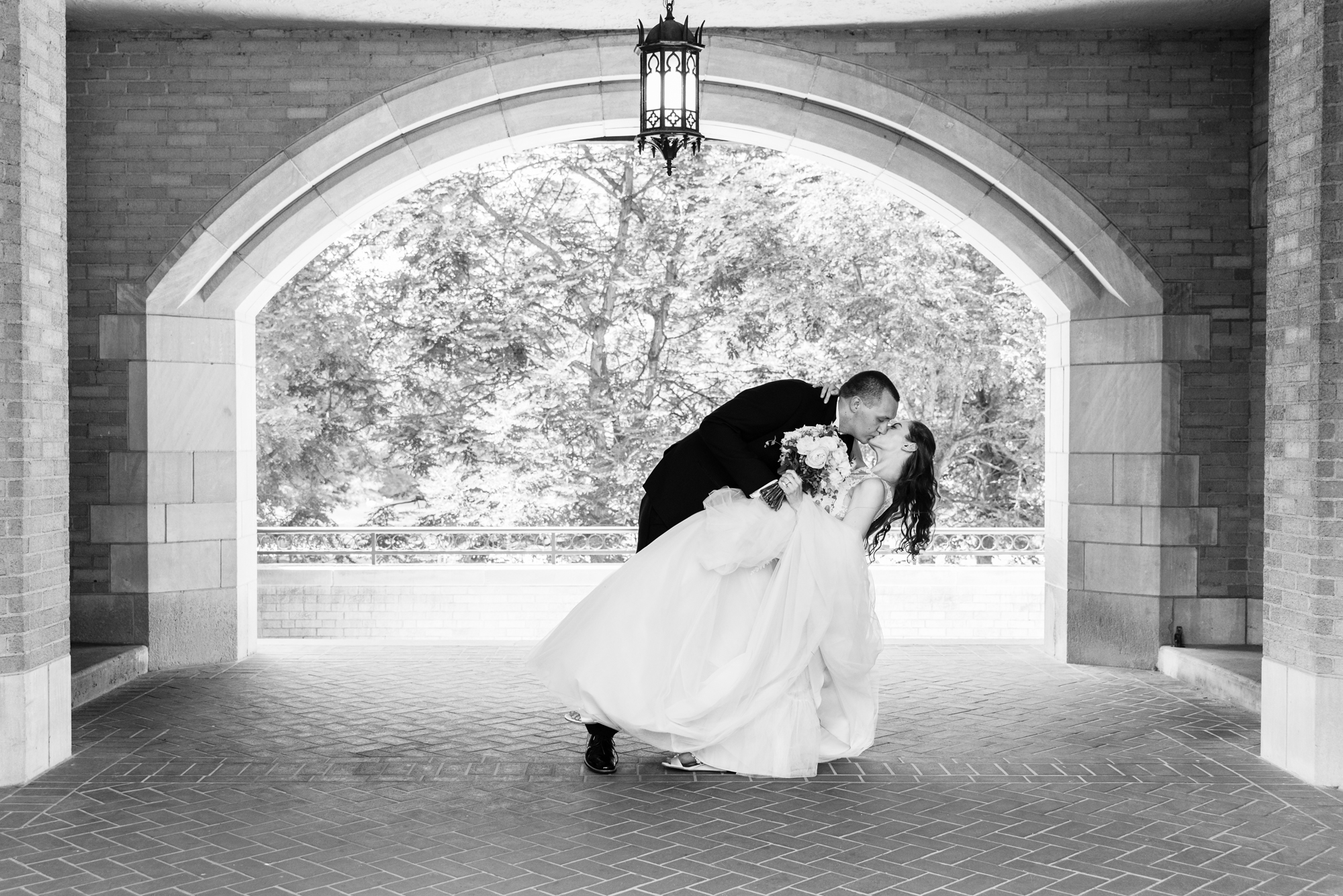 Bride & Groom under Lyons Hall arch after their wedding ceremony at the Basilica of the Sacred Heart on the campus of the University of Notre Dame