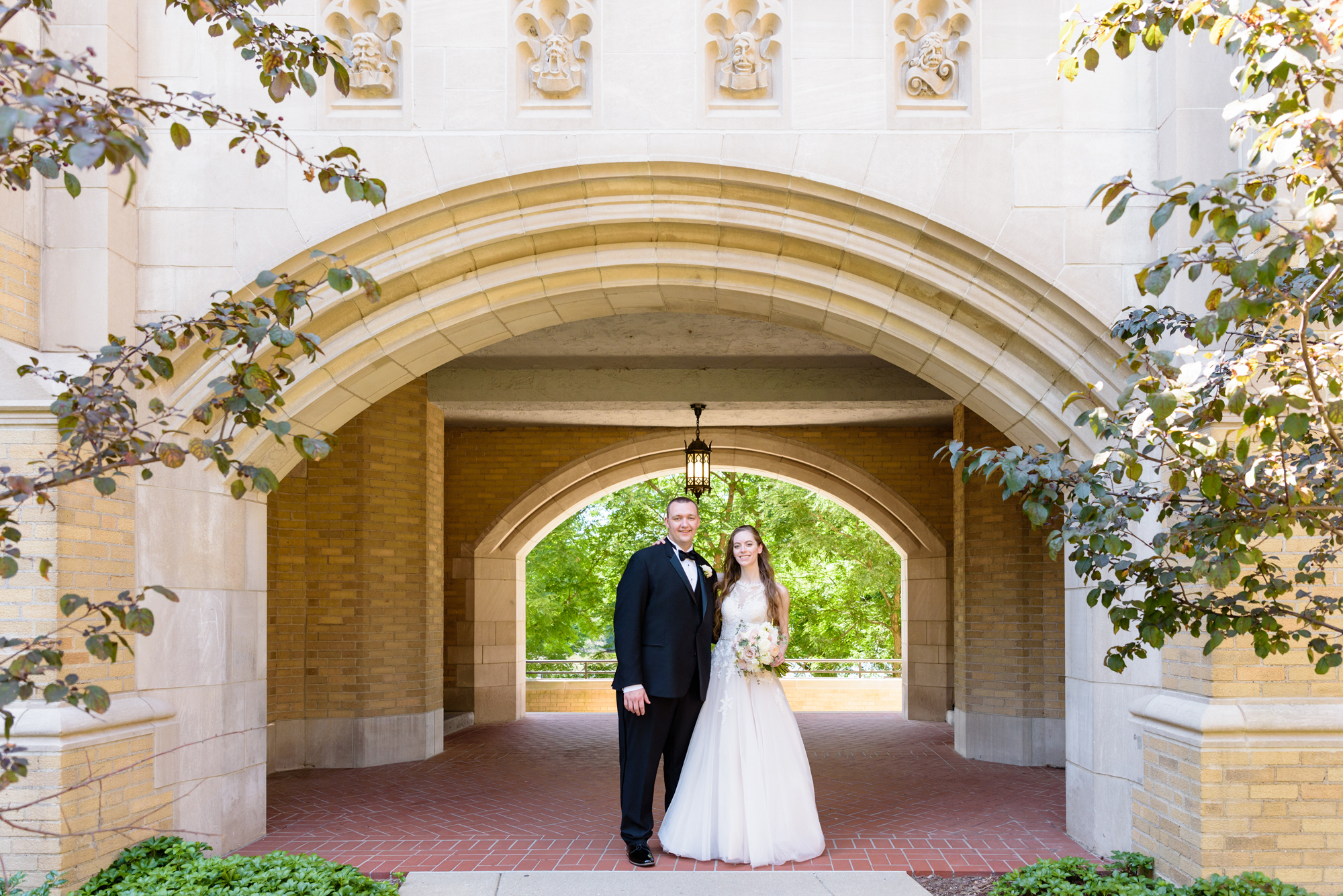 Bride & Groom under Lyons Hall arch after their wedding ceremony at the Basilica of the Sacred Heart on the campus of the University of Notre Dame