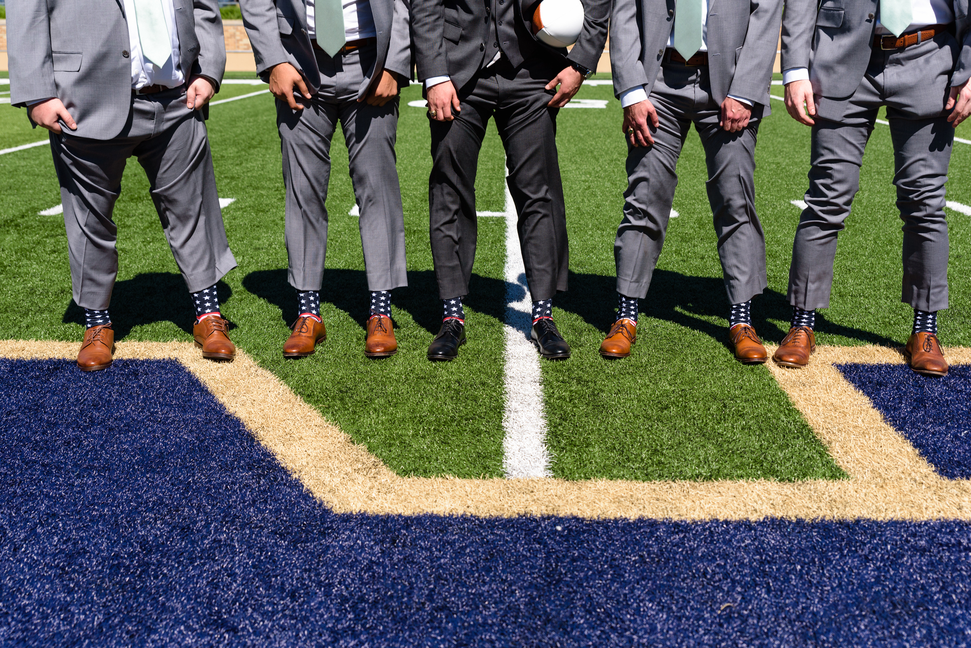 Groomsmen socks in the Football Stadium after their wedding ceremony at the Basilica of the Sacred Heart on the campus of the University of Notre Dame