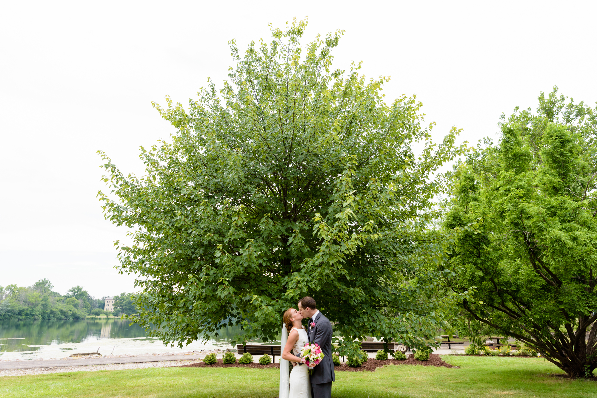 Bride & Groom in front of a tree by St Mary's Lake after their wedding ceremony at the Basilica of the Sacred Heart on the campus of the University of Notre Dame