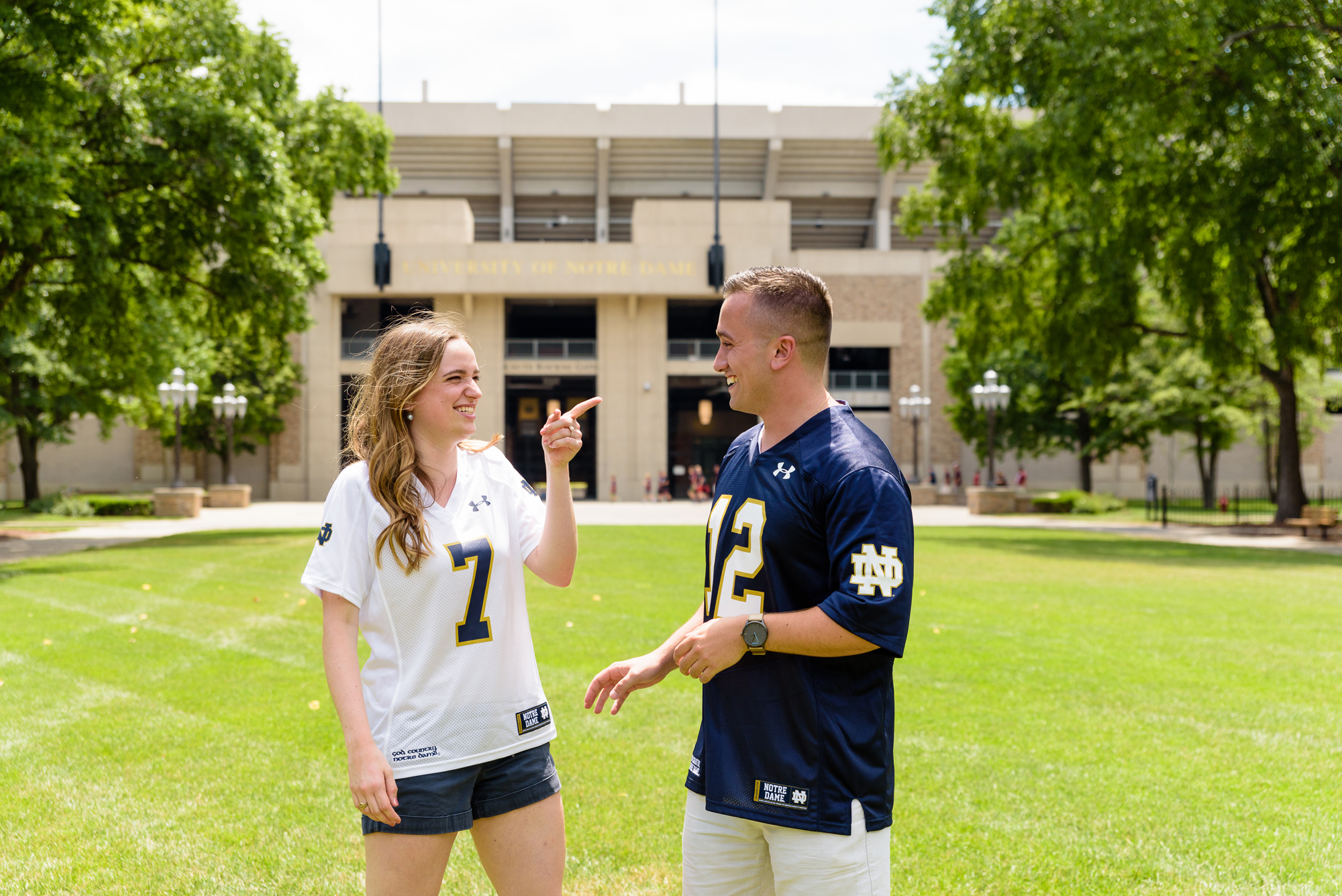 Engaged couple in front of the football Stadium on the campus of the University of Notre Dame