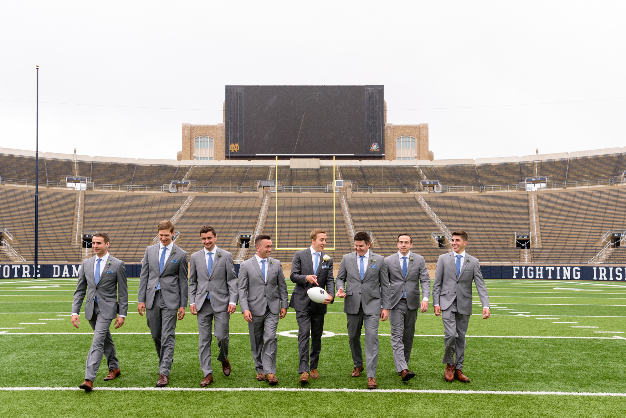 Groomsmen on Notre Dame football field after their wedding ceremony at the Basilica of the Sacred Heart on the campus of the University of Notre Dame