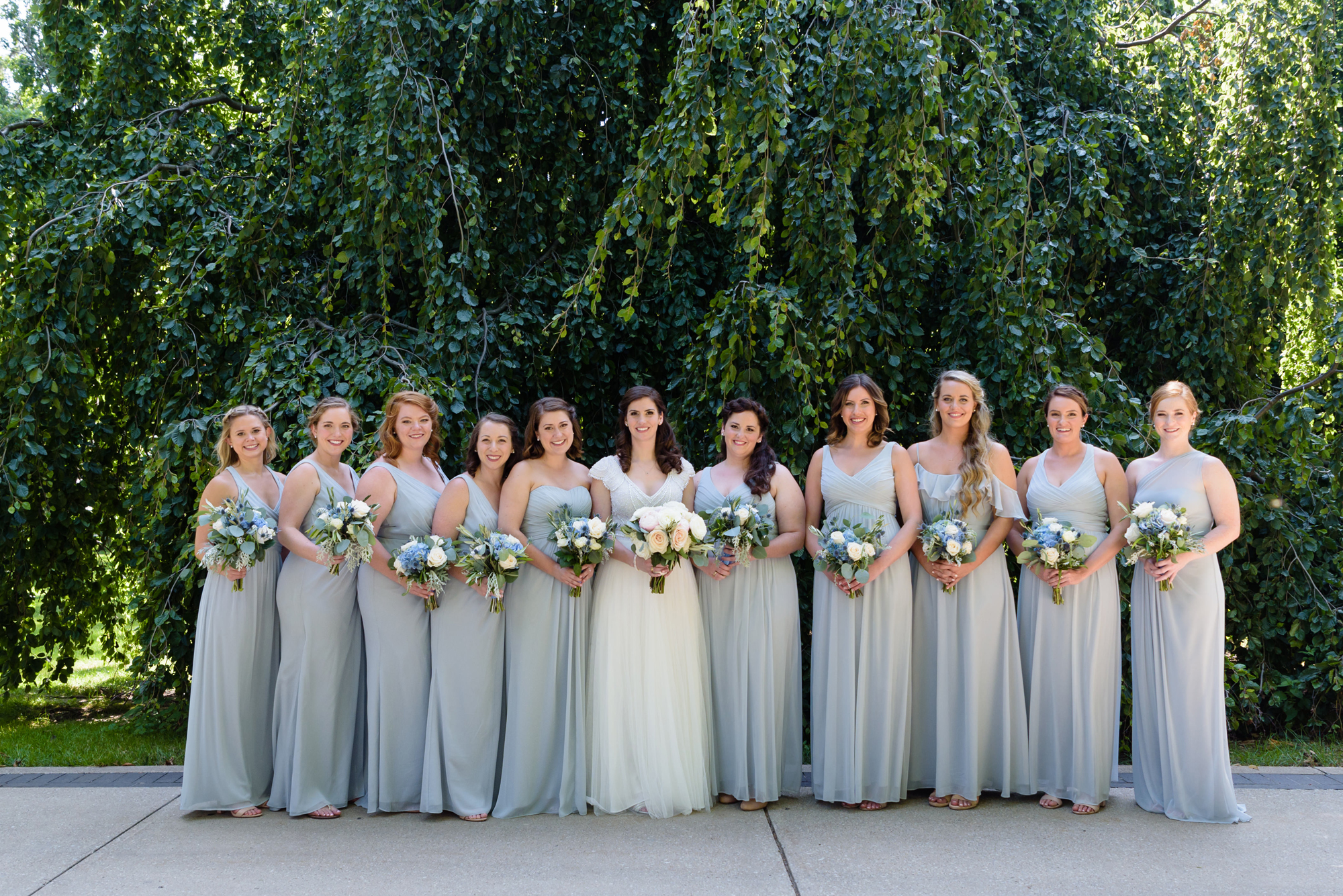 Bridesmaids in front of an exotic California inspired tree after a wedding ceremony at the Basilica of the Sacred Heart on the campus of the University of Notre Dame