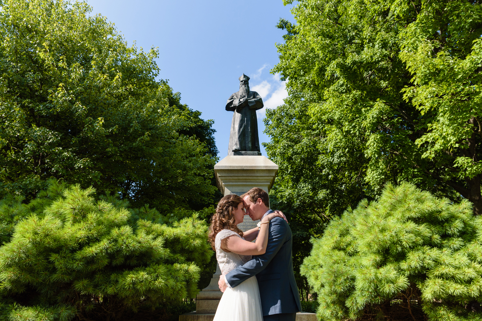 Bride & Groom in front of Father Sorin statue after their wedding ceremony at the Basilica of the Sacred Heart on the campus of the University of Notre Dame