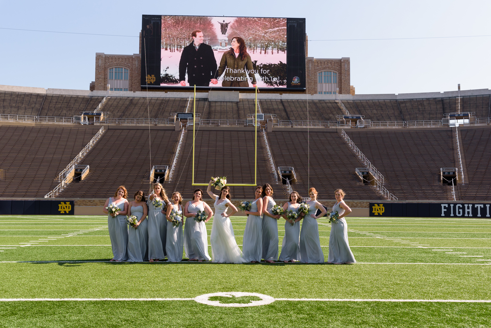 Bridesmaids on Notre Dame football field after their wedding ceremony at the Basilica of the Sacred Heart on the campus of the University of Notre Dame