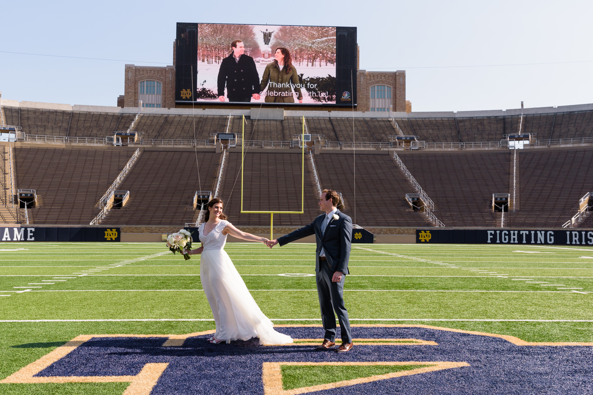 Bride & Groom on Notre Dame football field after their wedding ceremony at the Basilica of the Sacred Heart on the campus of the University of Notre Dame
