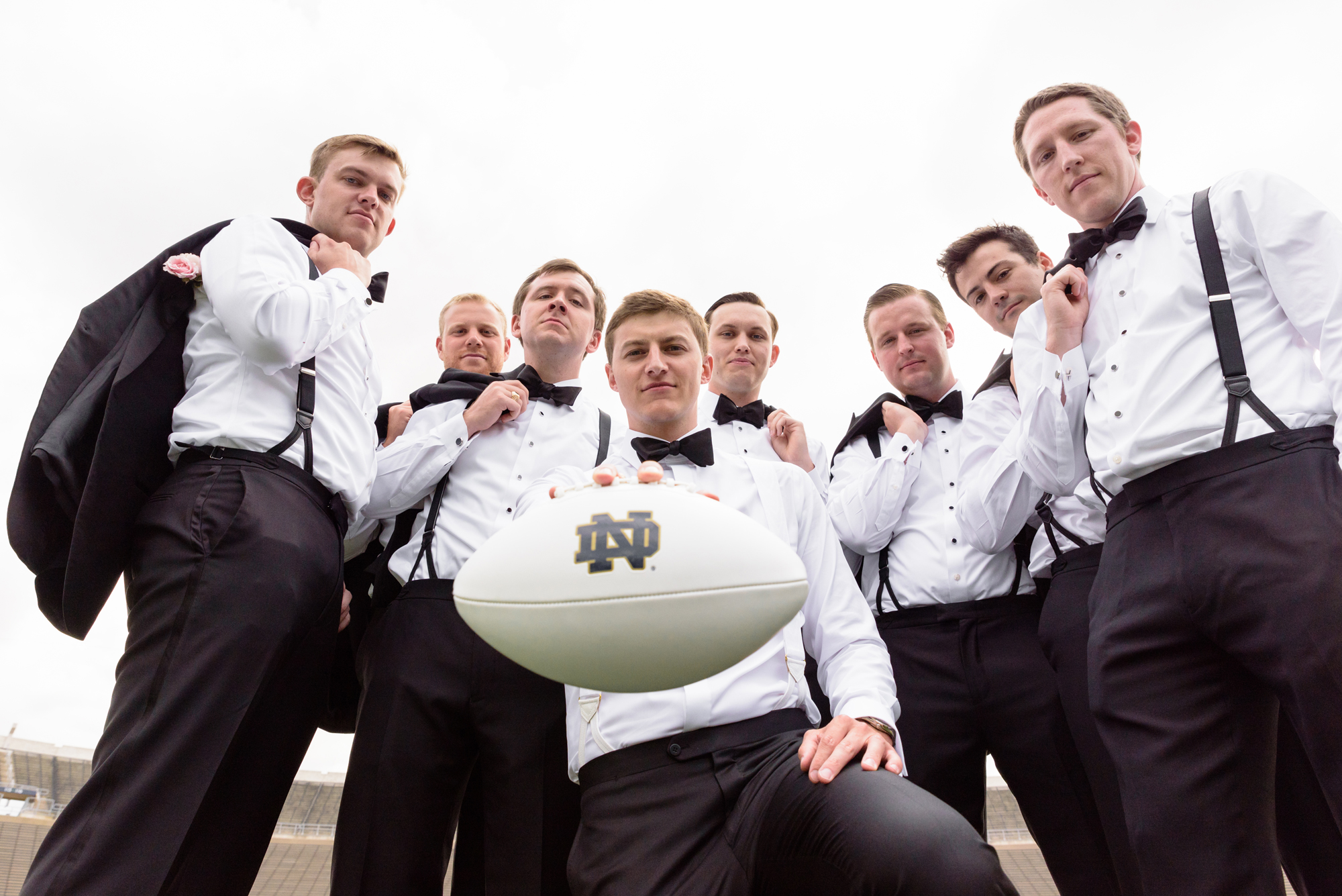 Groomsmen on Notre Dame football field after their wedding ceremony at the Basilica of the Sacred Heart on the campus of the University of Notre Dame