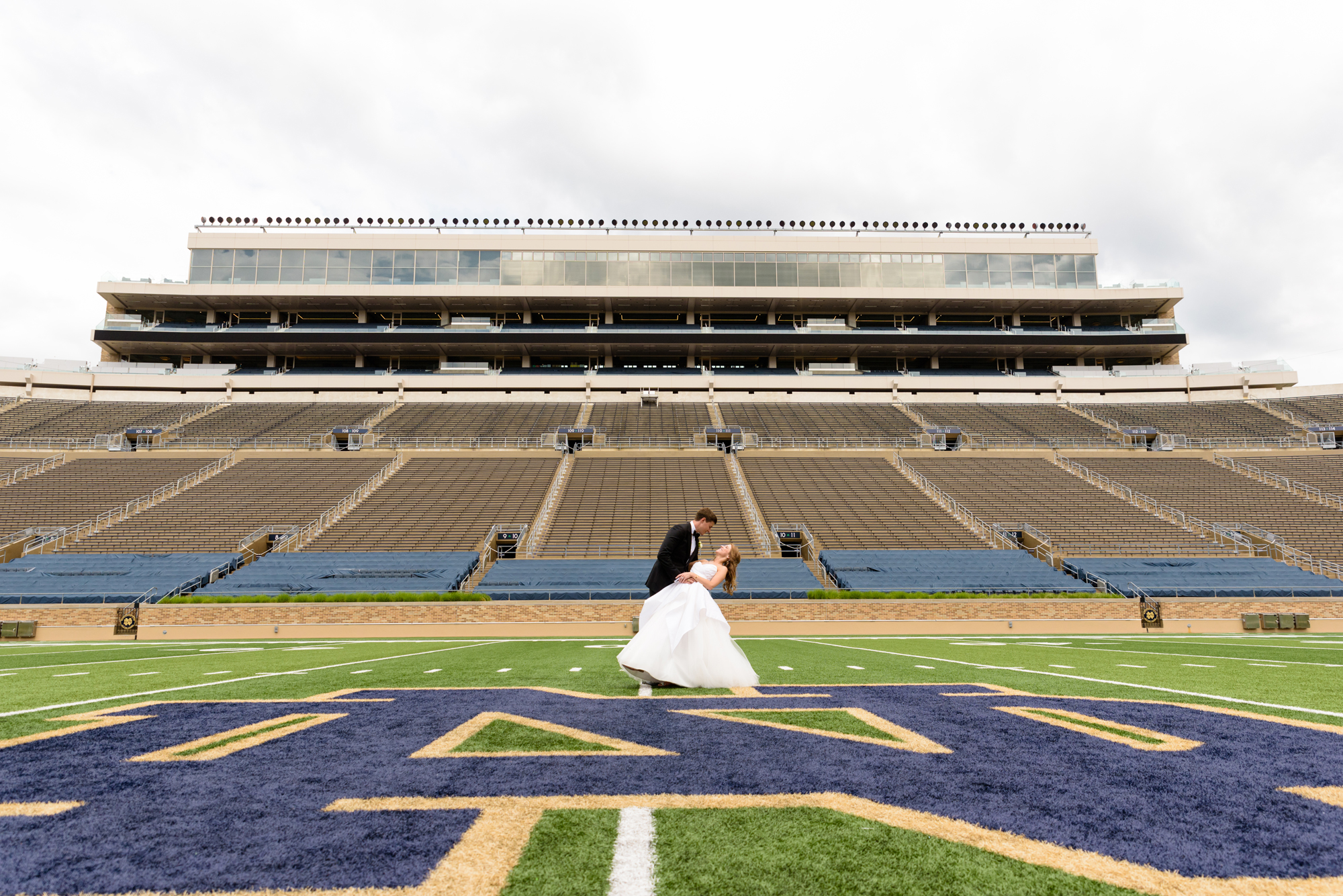 Bride & Groom on Notre Dame football field after their wedding ceremony at the Basilica of the Sacred Heart on the campus of the University of Notre Dame