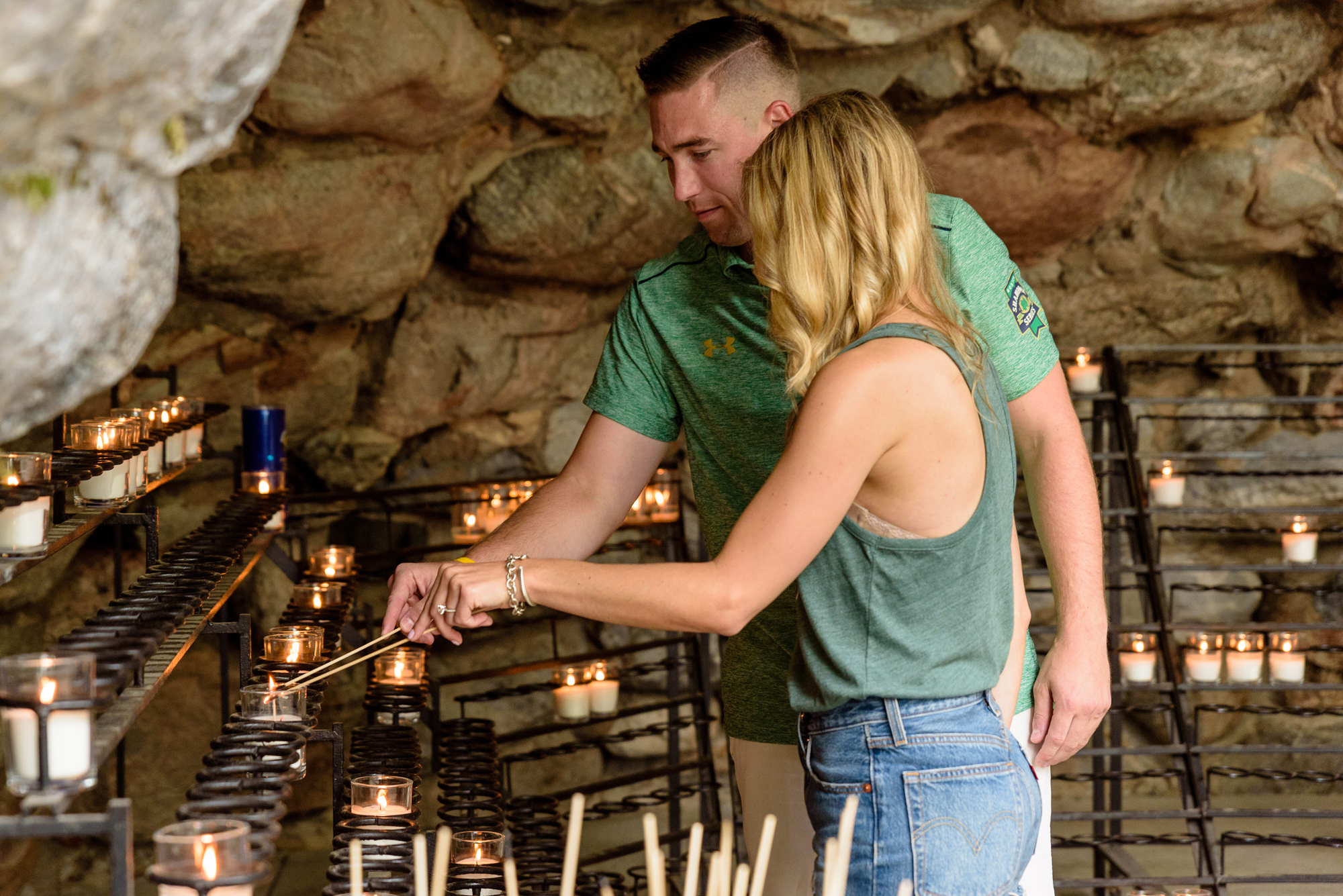 Newly engaged couple light a candle at the Grotto after he proposed on the campus of University of Notre Dame