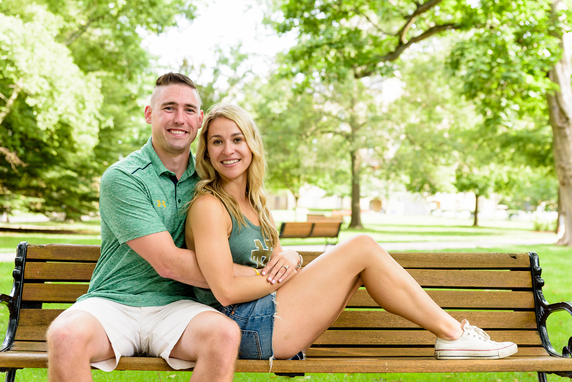 Newly engaged couple posed for photos on a bench on God Quad after he proposed on the campus of University of Notre Dame