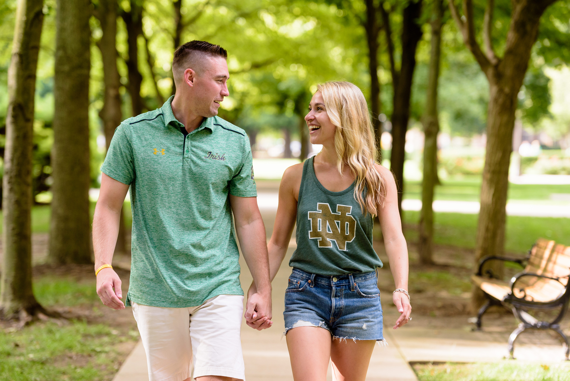 Newly engaged couple posed for photos down the row of trees on God Quad after he proposed on the campus of University of Notre Dame