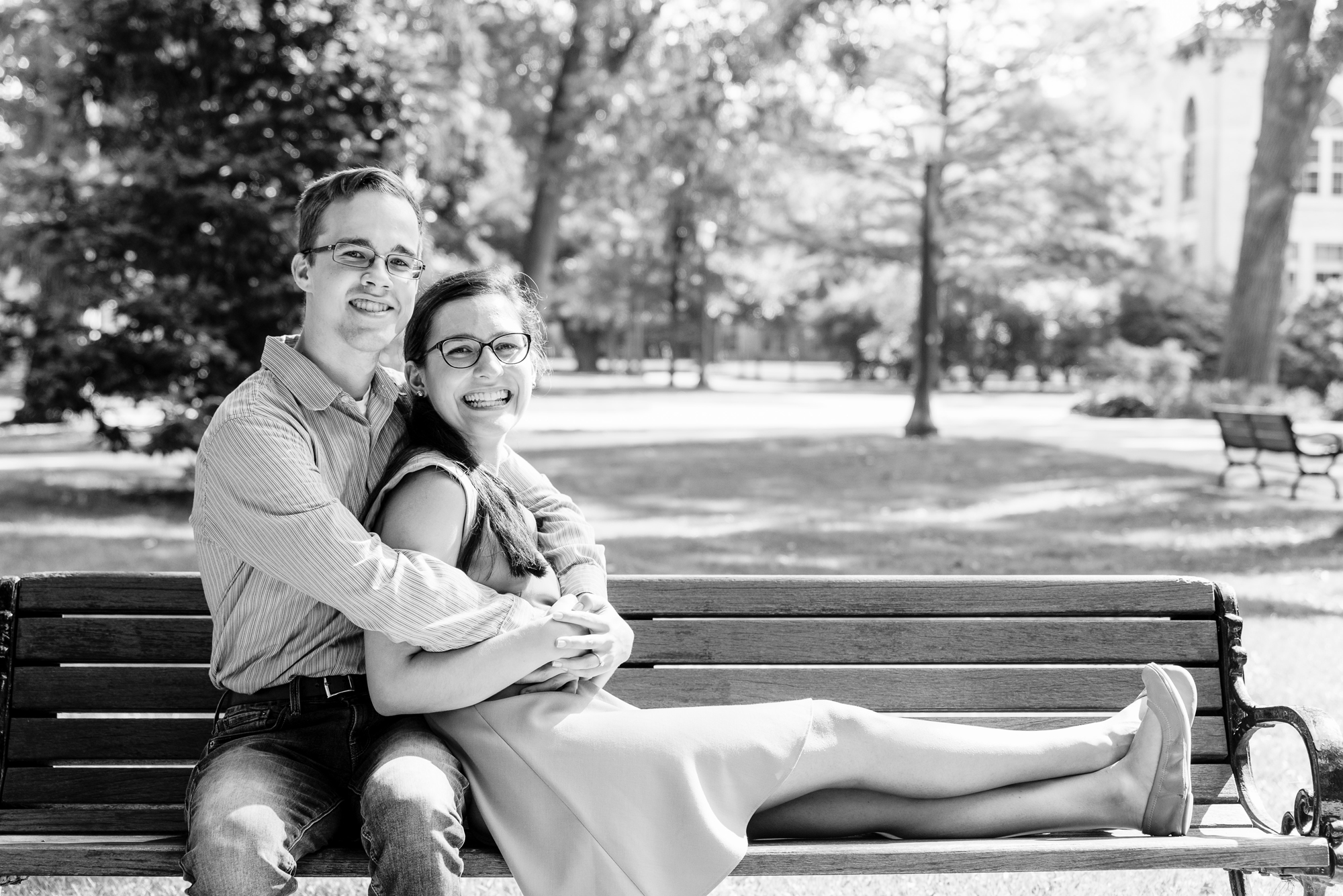 Engaged couple on a bench on God Quad on the campus of the University of Notre Dame