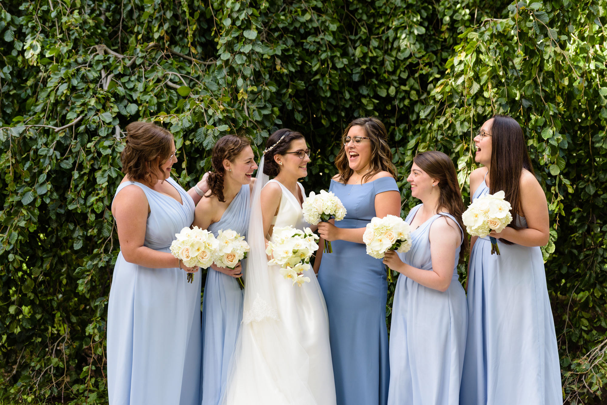Bridesmaids in front of an exotic tree on God Quad after a wedding ceremony at the Basilica of the Sacred Heart on the campus of the University of Notre Dame