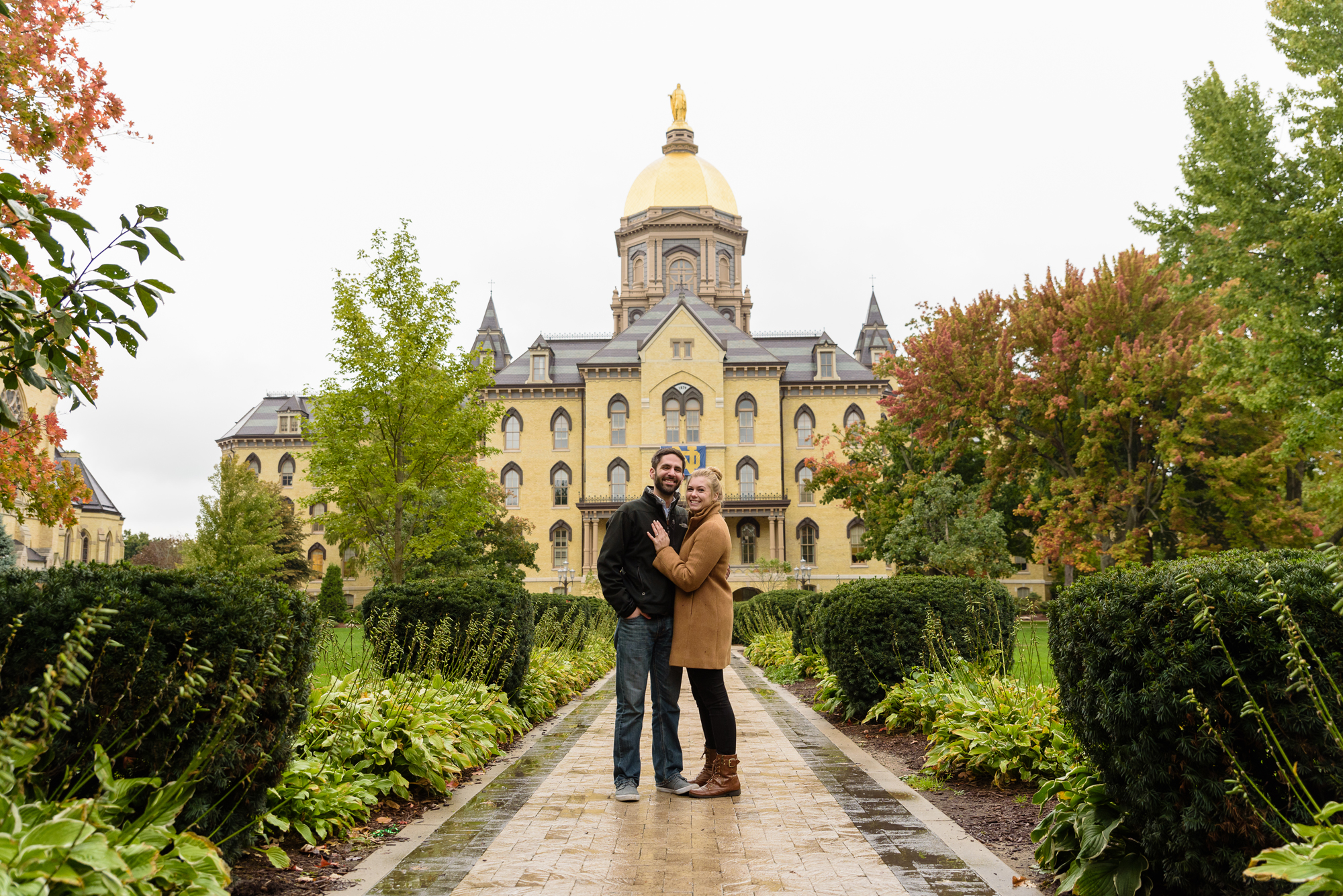Newly engaged couple in front of the Golden Dome on the campus of the University of Notre Dame