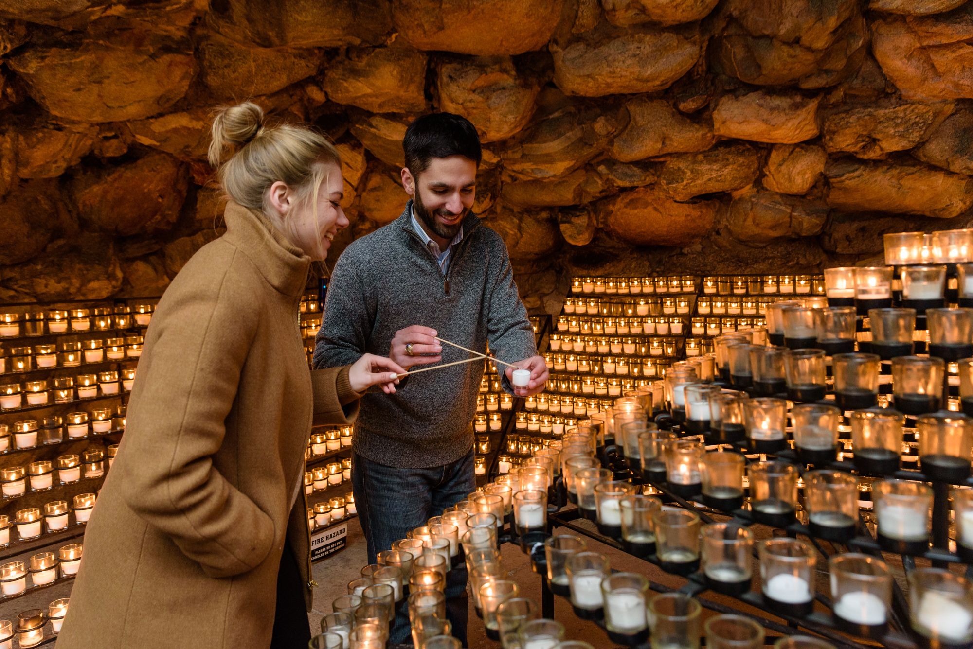 Newly engaged couple lighting a candle at the Grotto on the campus of the University of Notre Dame