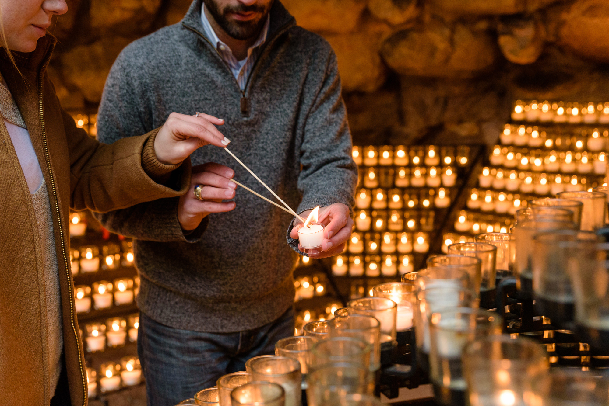 Newly engaged couple lighting a candle at the Grotto on the campus of the University of Notre Dame