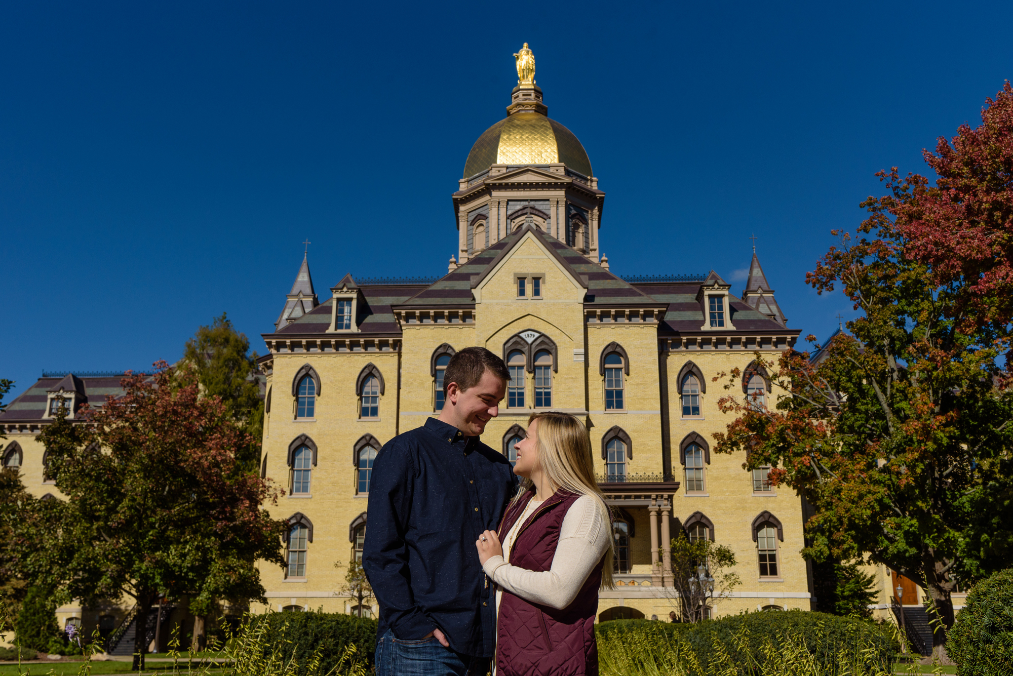 Engaged couple in front of the Golden Dome on the campus of the University of Notre Dame