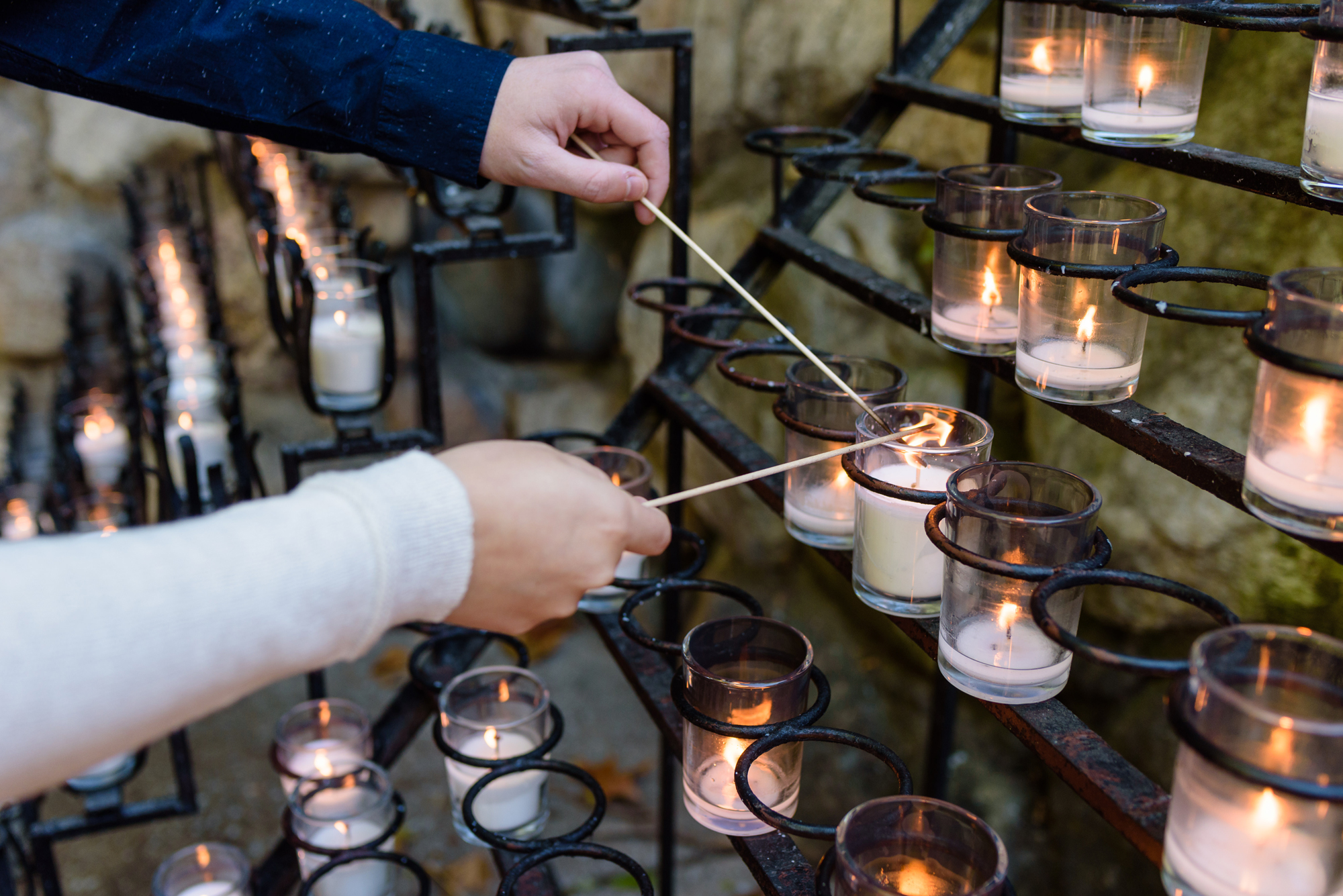 Engaged couple lighting a candle at the Grotto on the campus of the University of Notre Dame