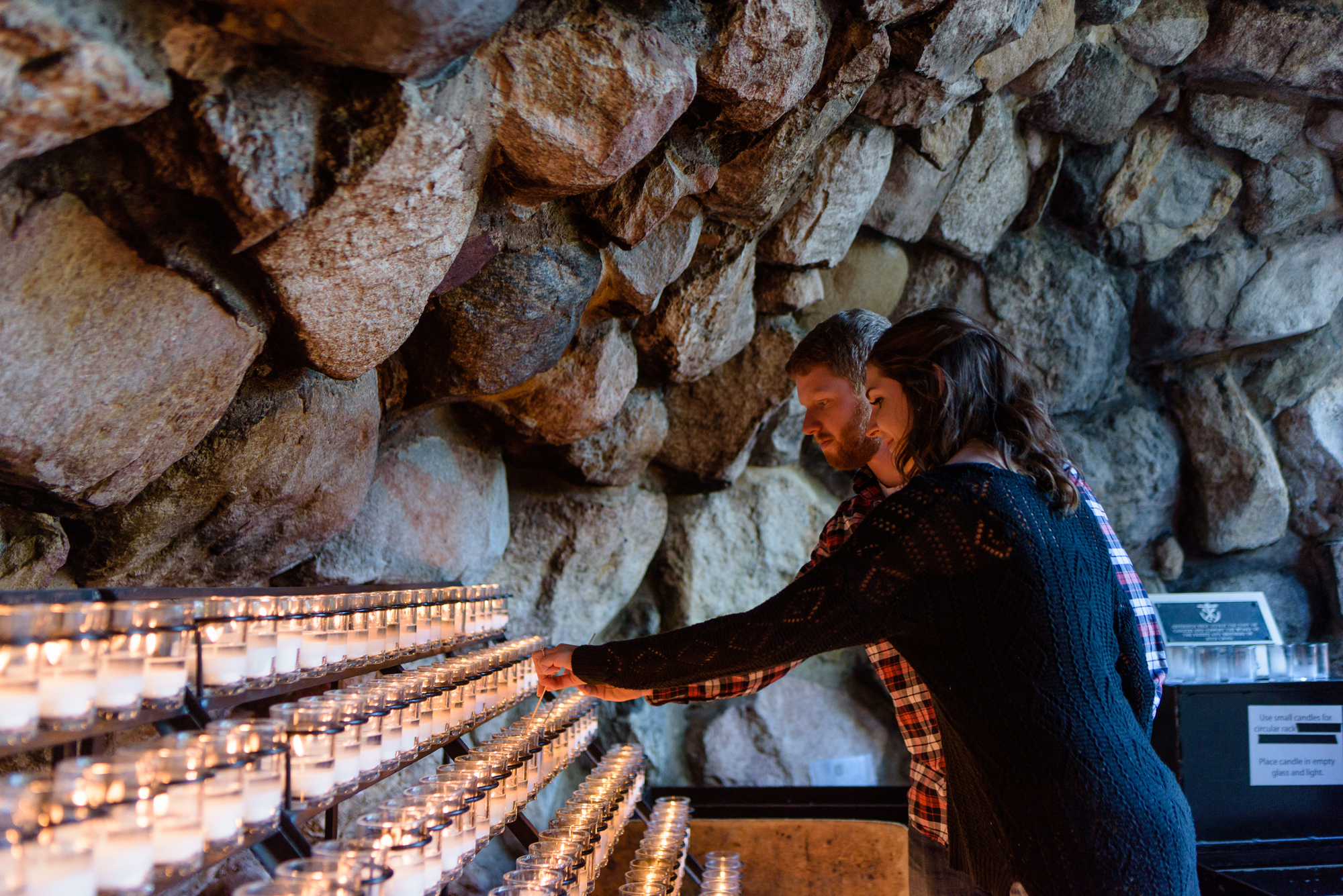 Engaged couple lighting a candle at the Grotto on the campus of the University of Notre Dame