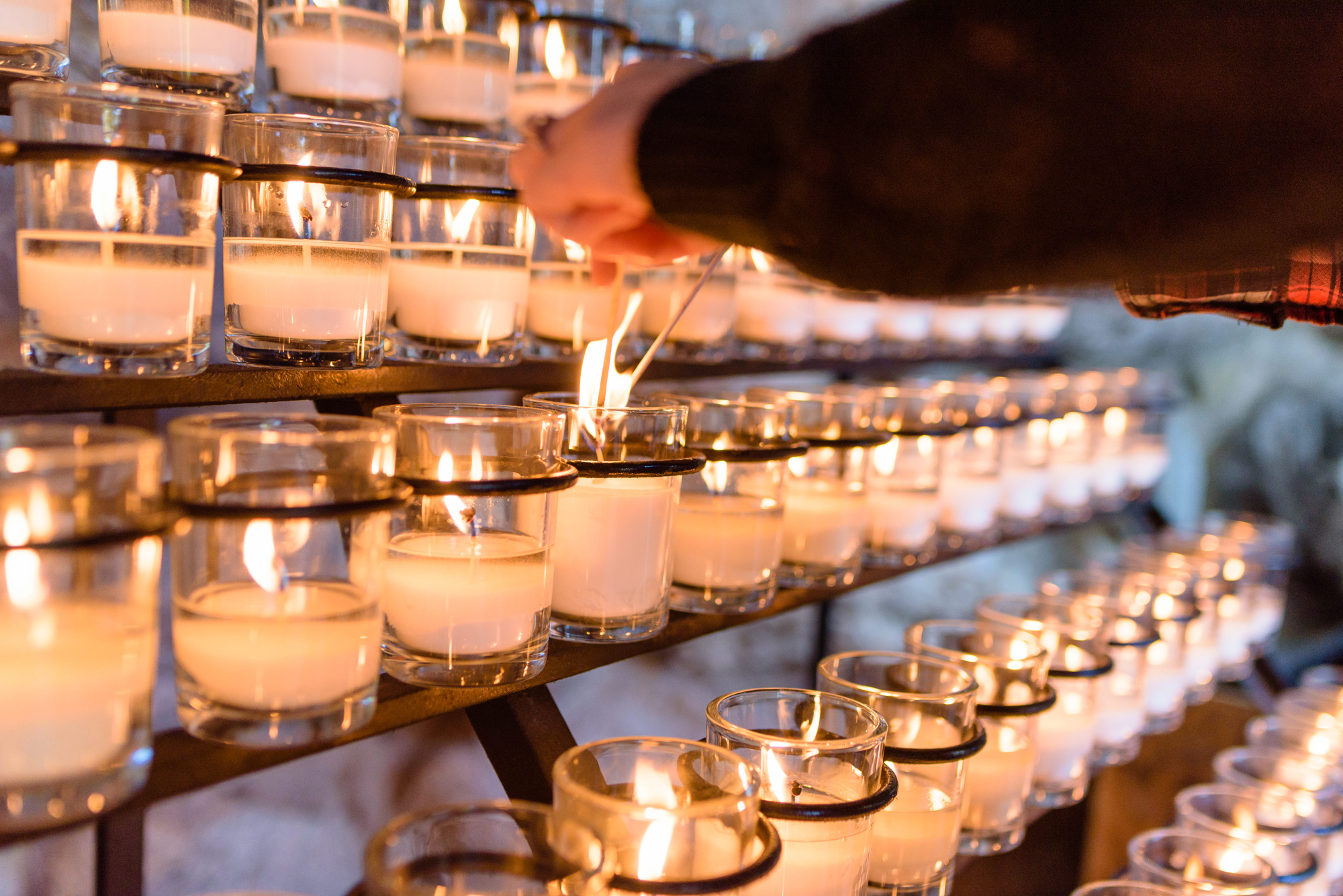 Engaged couple lighting a candle at the Grotto on the campus of the University of Notre Dame