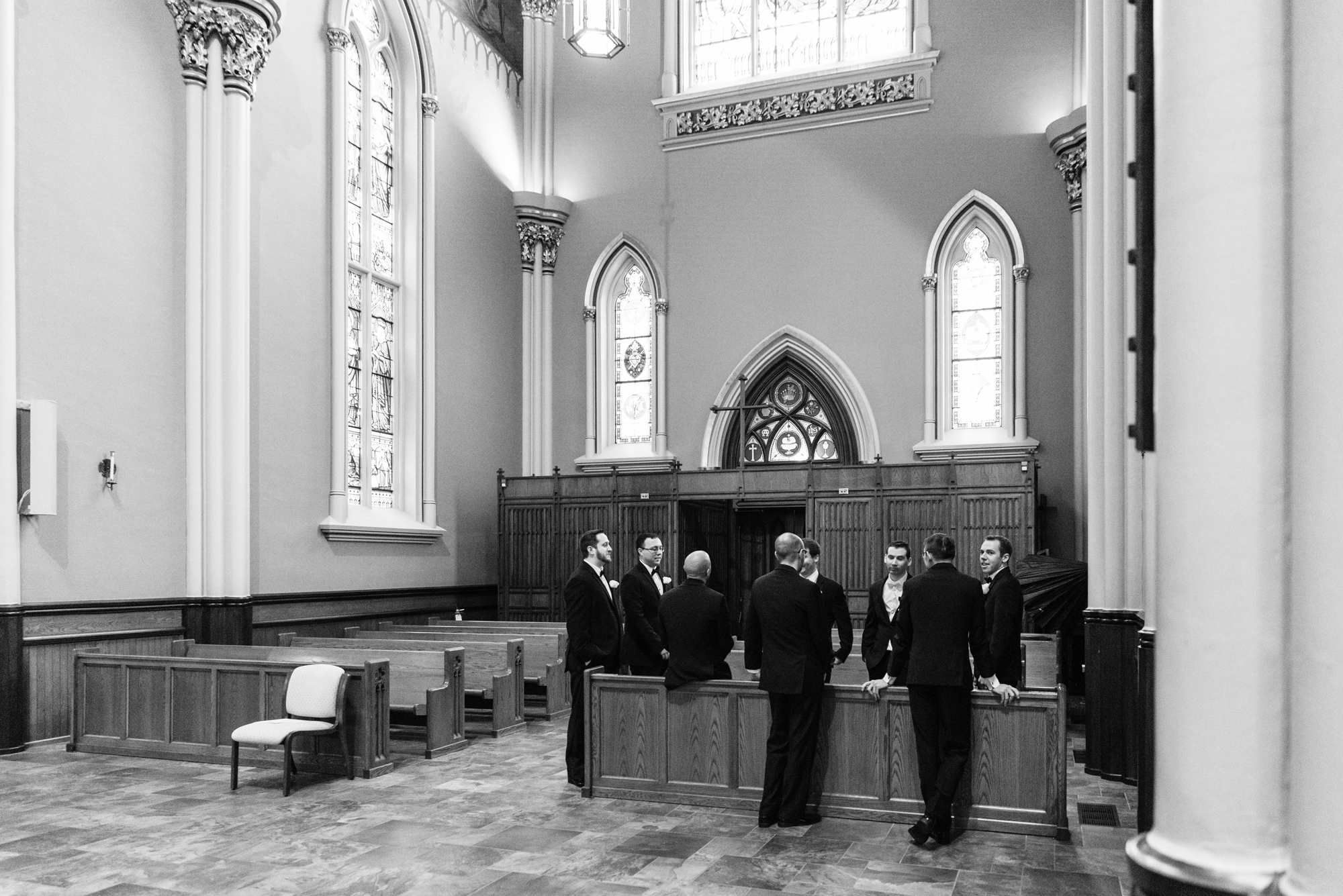 Groom praying with her bridesmaids before their wedding ceremony at the Basilica of the Sacred Heart on the campus of the University of Notre Dame