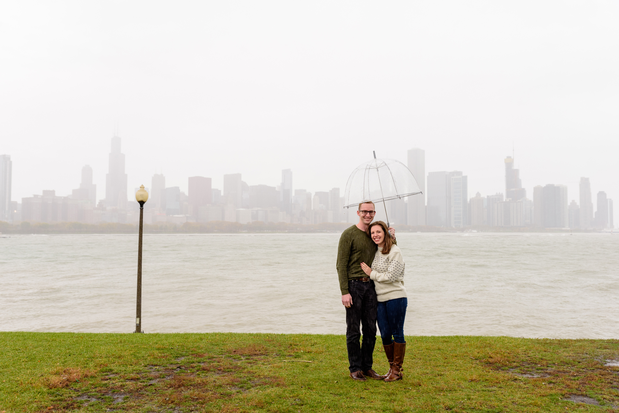 Engaged couple at the Planetarium with the Chicago skyline behind them