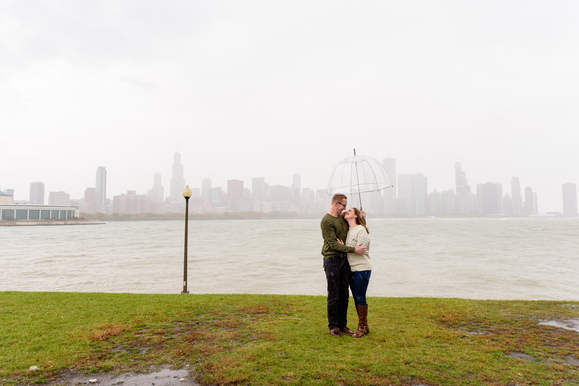 Engaged couple at the Planetarium with the Chicago skyline behind them