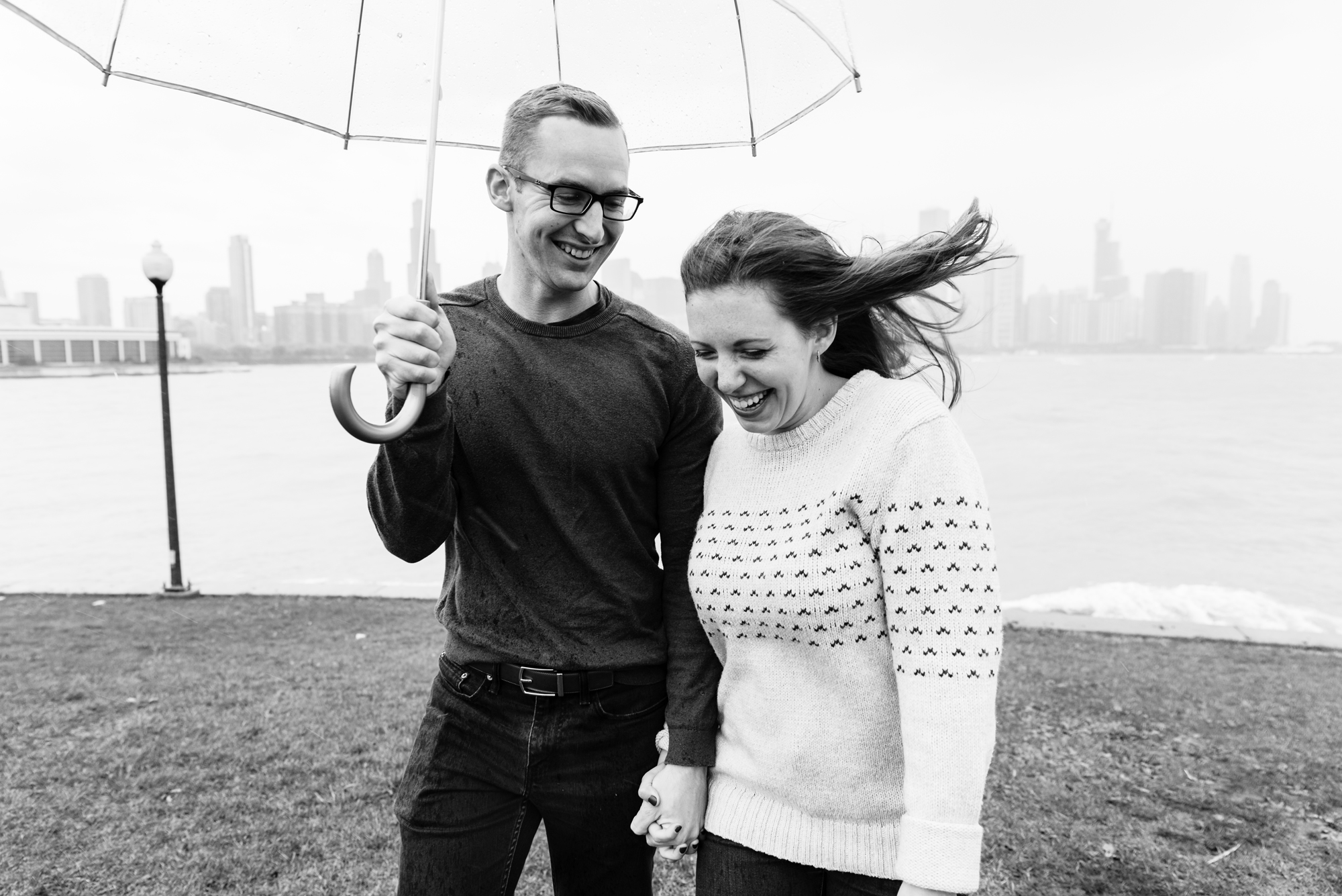 Engaged couple at the Planetarium with the Chicago skyline behind them